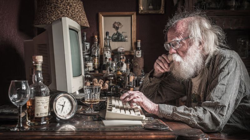 old man looking at his computer to send an e-mail